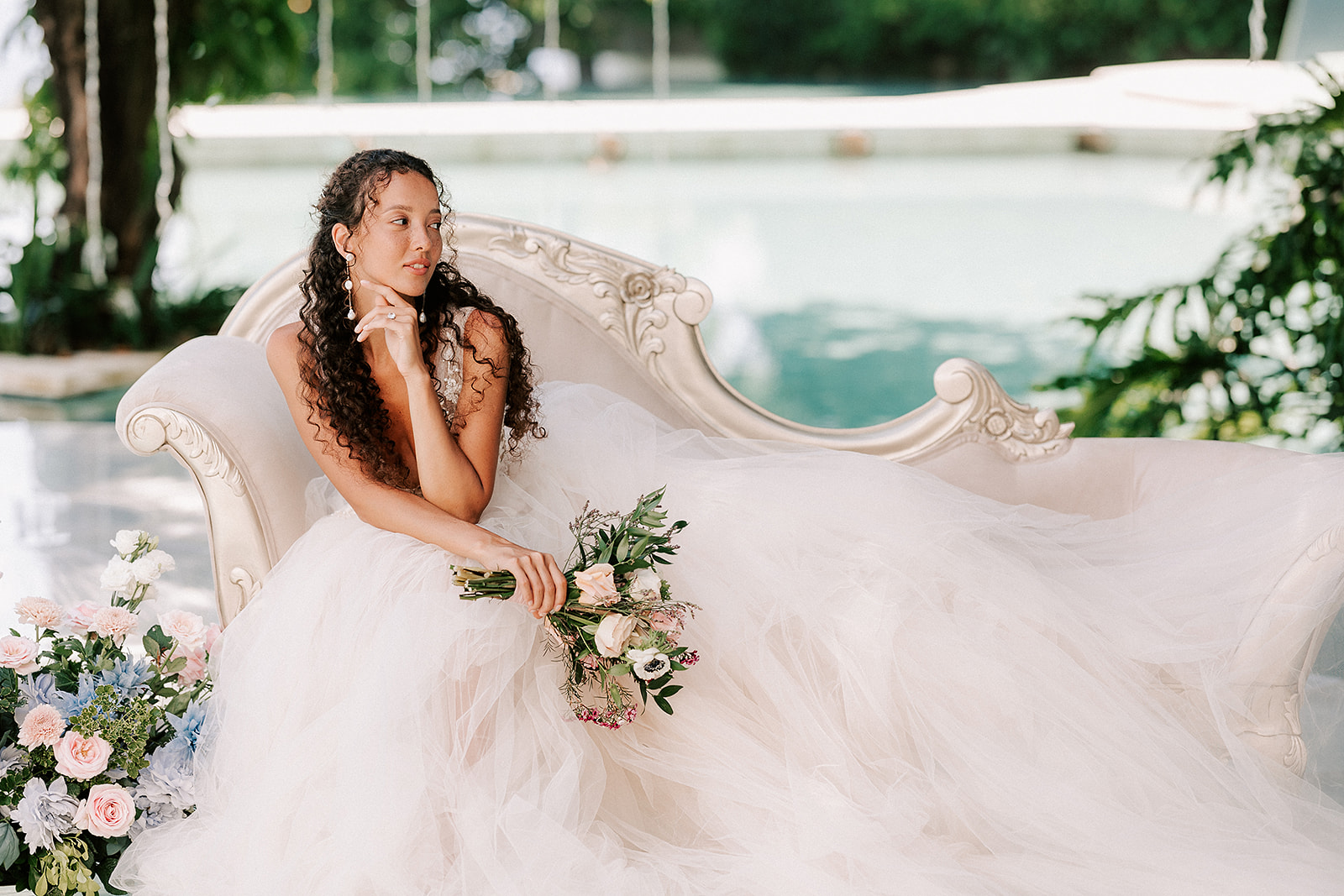 bride posing in dress sitting down with bouquet