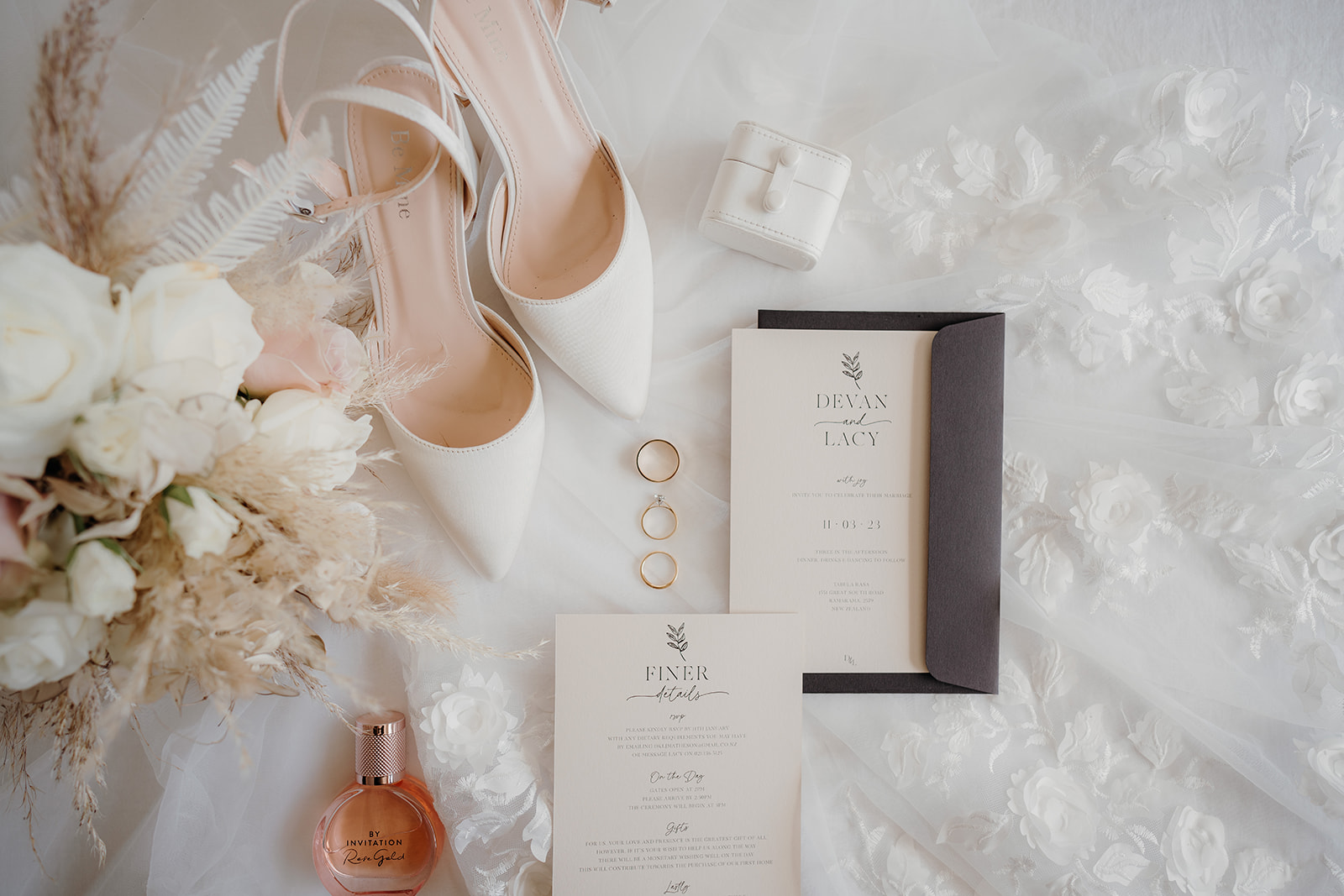 auckland wedding photographer takes a photo of the brides details and accessories including the rings, invitations ect