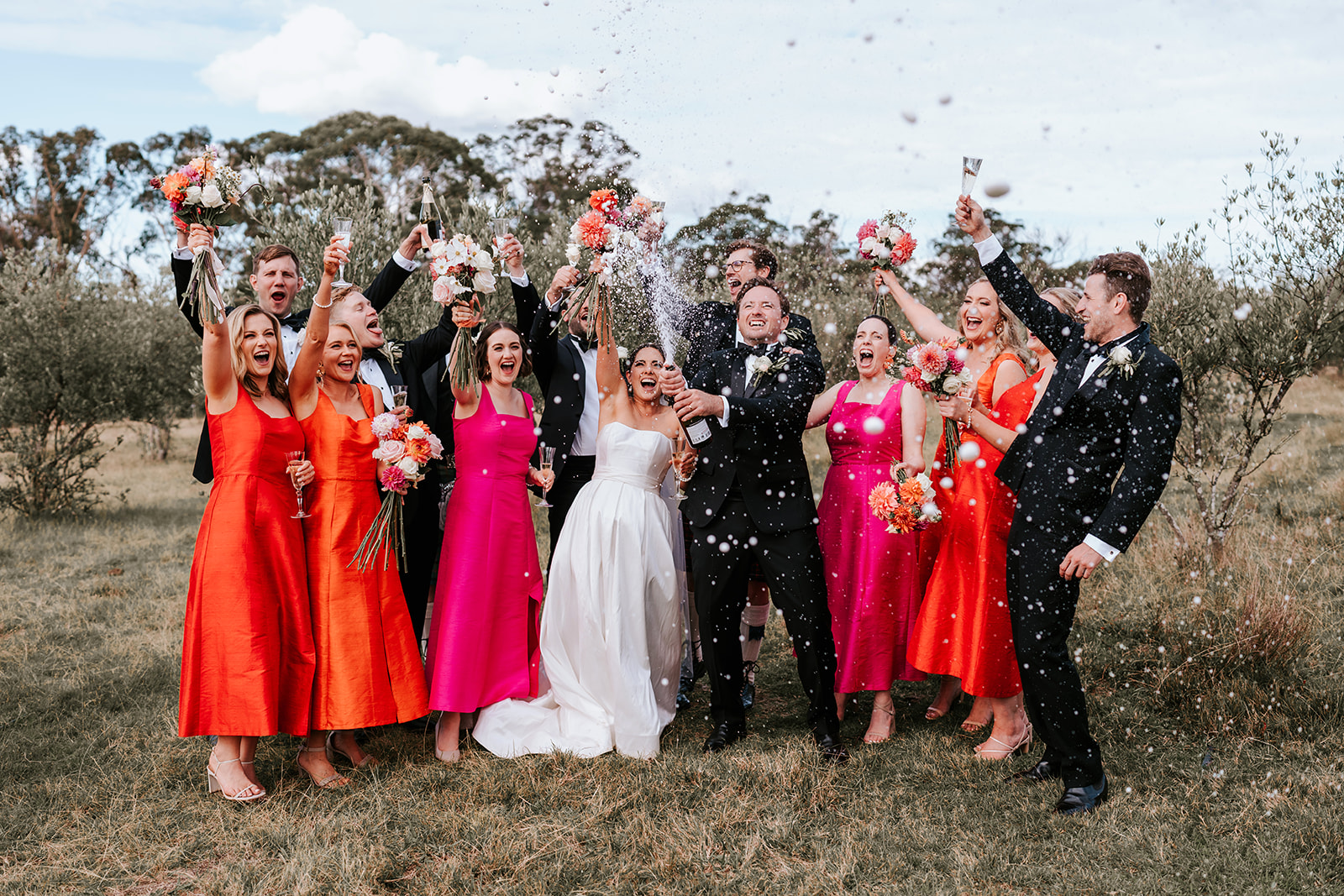 Bridal Party spraying bottle of champagne 