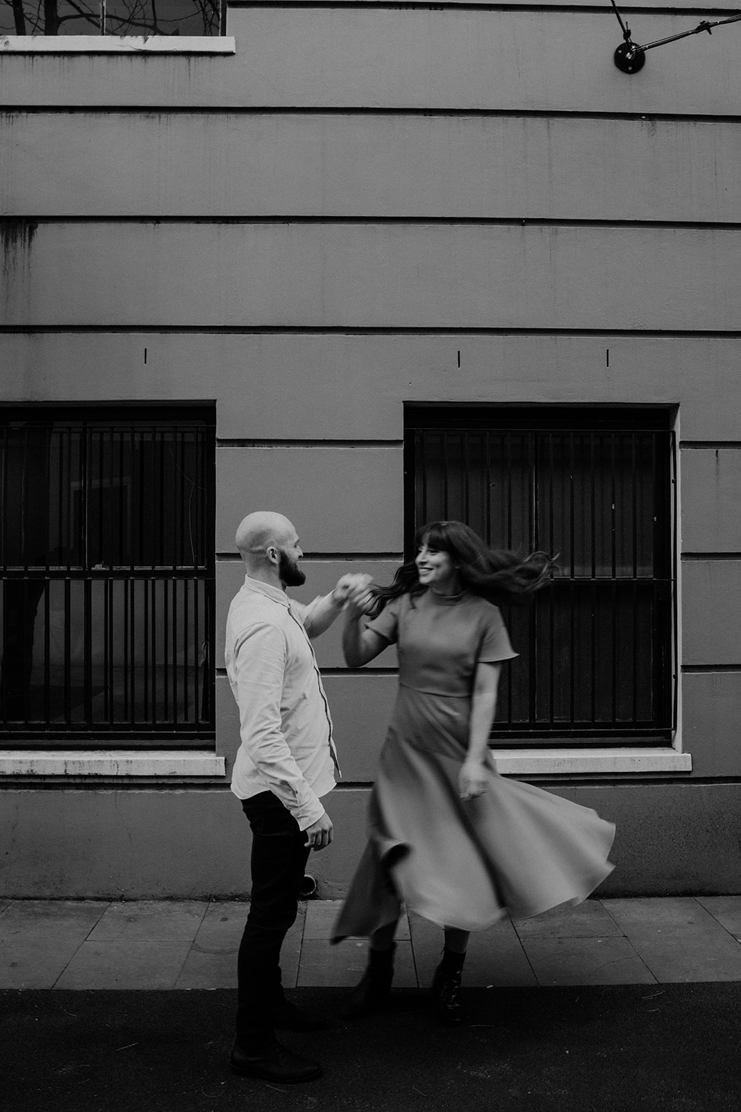 Couple happily dancing at their engagement shoot in Sydney CBD