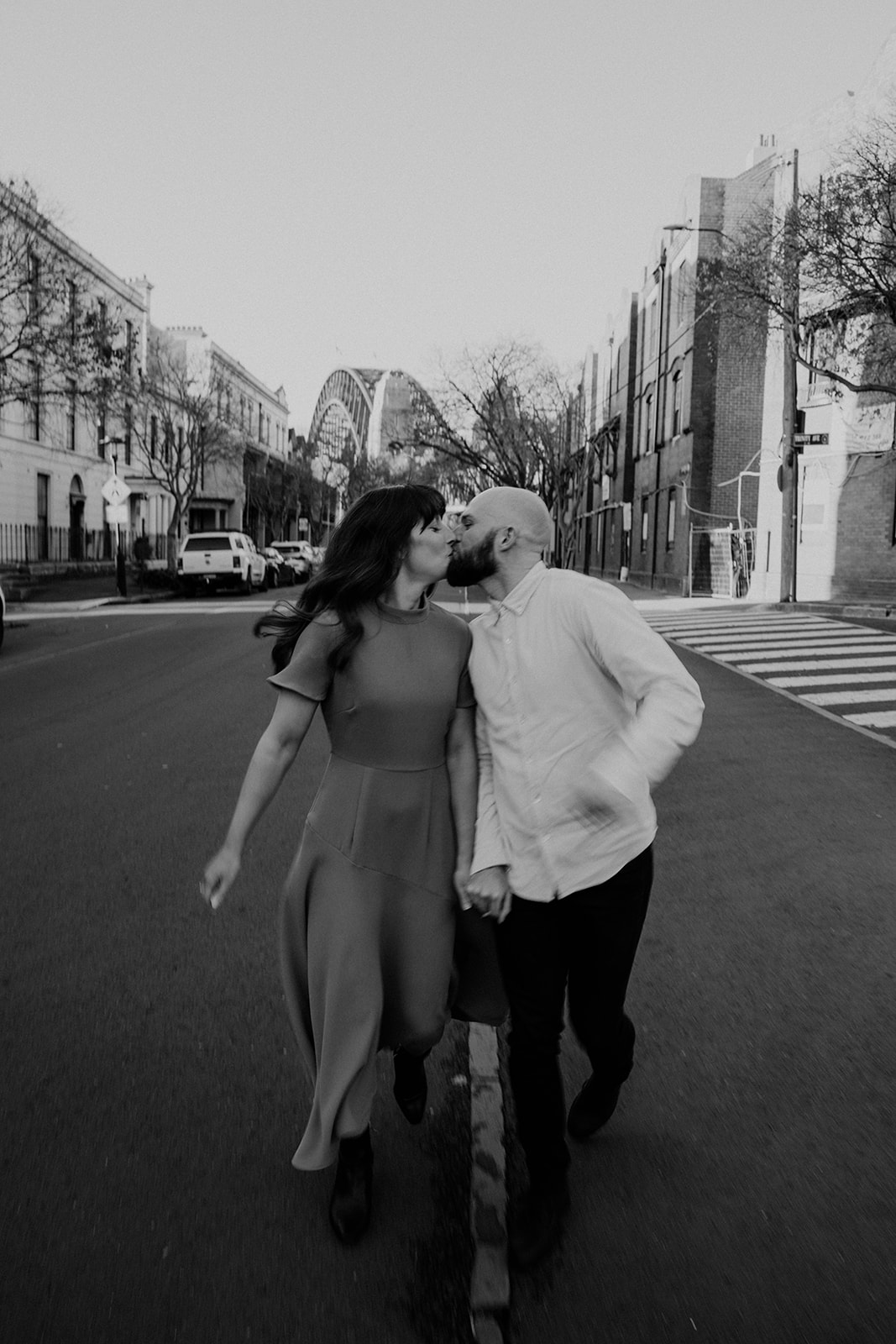 Couple kissed while walking in the city at their engagement shoot in Sydney CBD