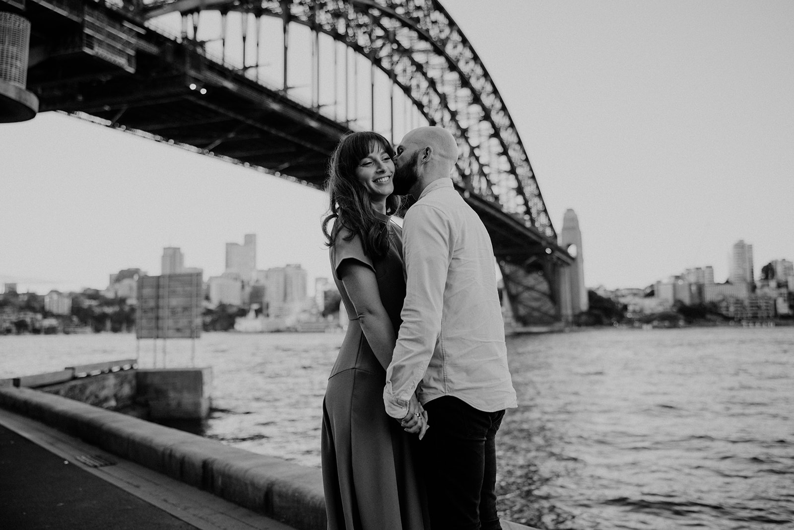 Soon to be groom quick kiss at their engagement shoot in Sydney CBD