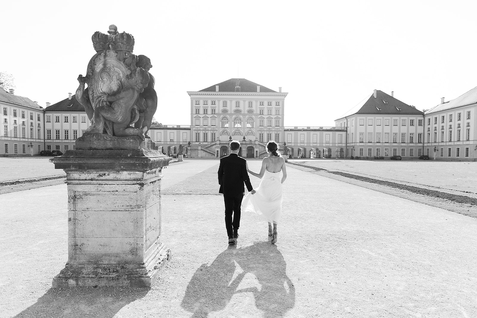 Bride and groom walk in front of Schloss Nymphenburg in Munich, Germany for their editorial wedding portraits