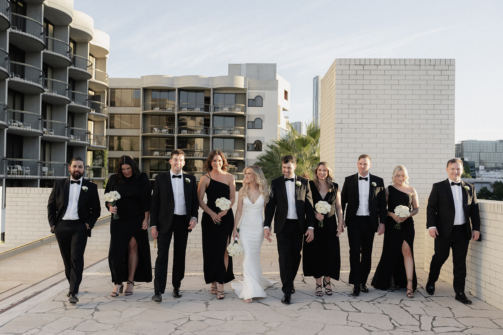 A sophisticated Black bridal party at The Calile Hotel amphitheatre for wedding photos