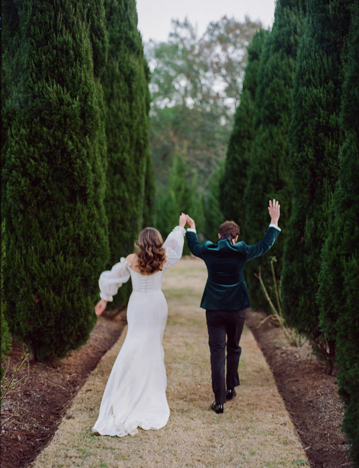 bride and groom celebrate holding hands in air and running