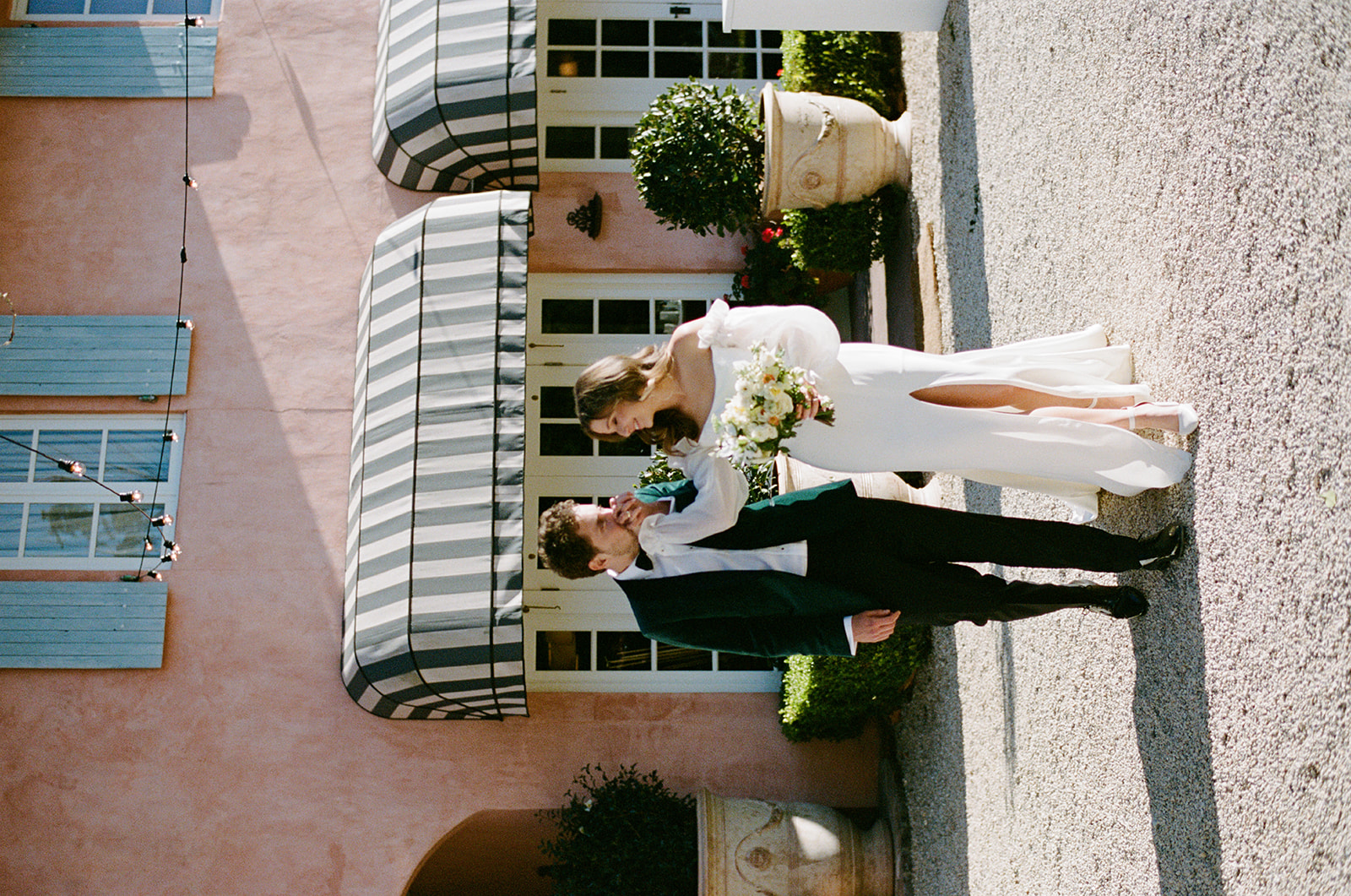 bride and groom on 35mm film as groom kisses brides hand at Redleaf wedding 