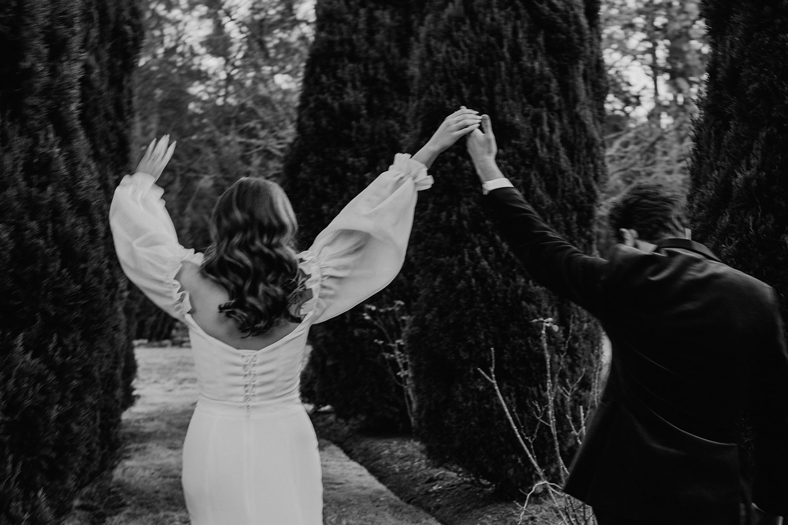 Redleaf wedding black and white image of couple hoding hands and hands in the air