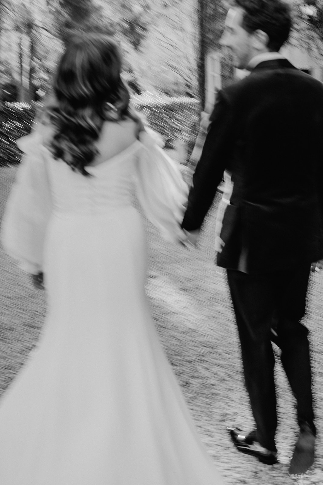 Redleaf wedding bride and groom hold hands and walk away from camera blurry