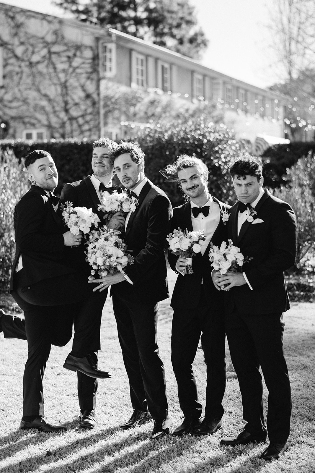 Redleaf wedding groomsmen pose with bouquets