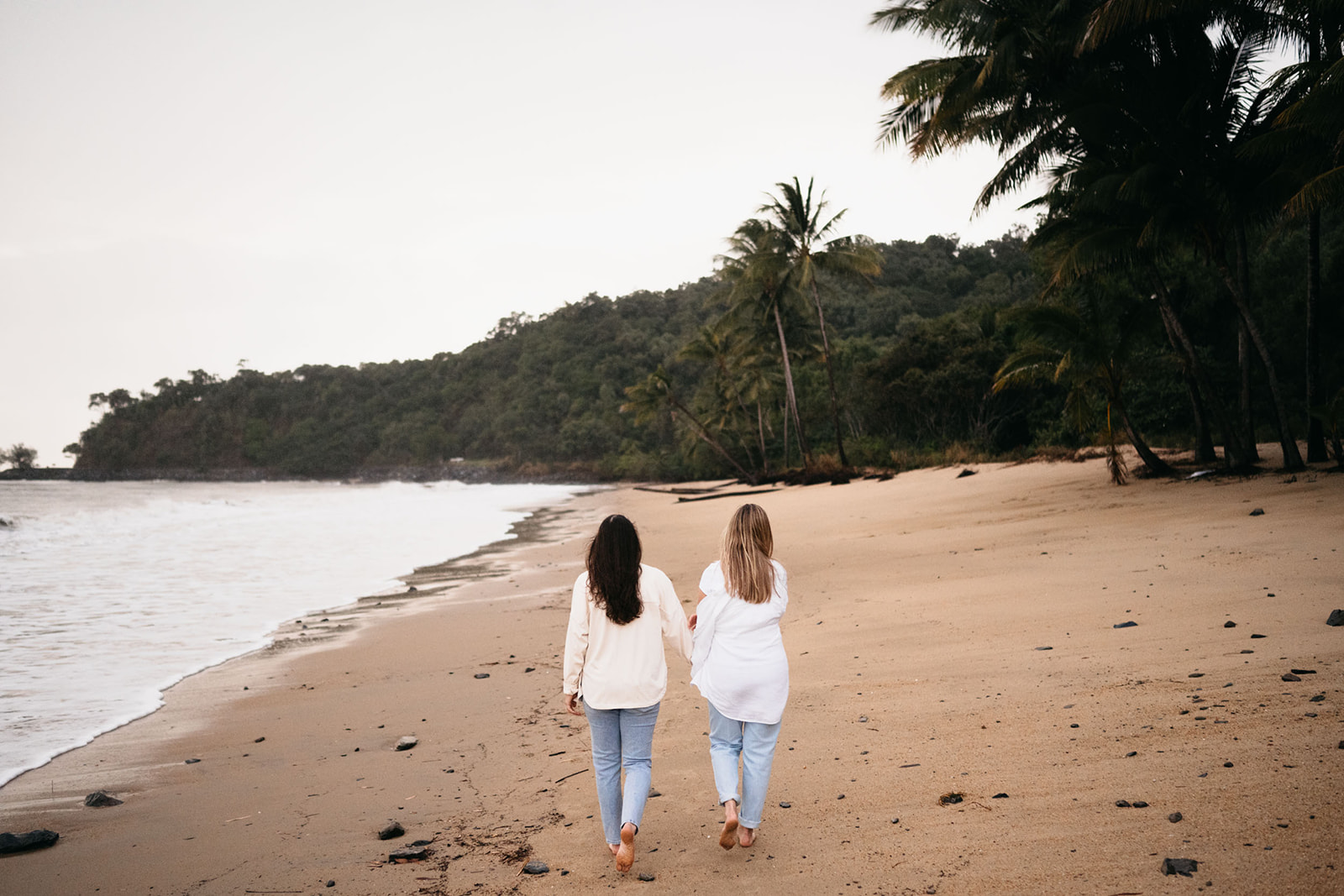 A couple walking on a Queensland beach for their engagement session