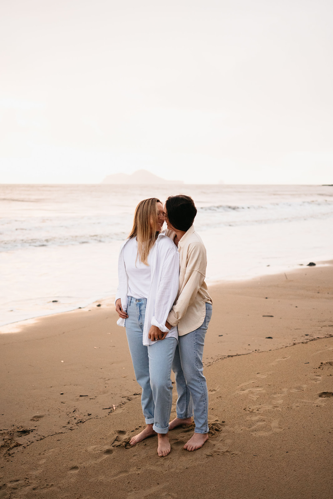 sunrise beach engagement session with couple