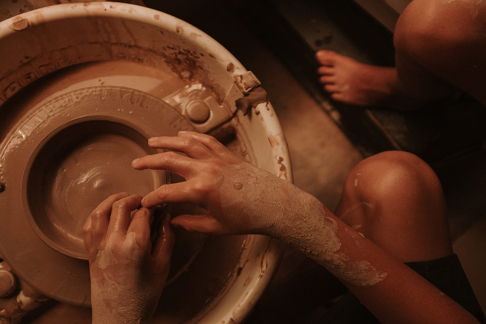 Young hands working on pottery wheel