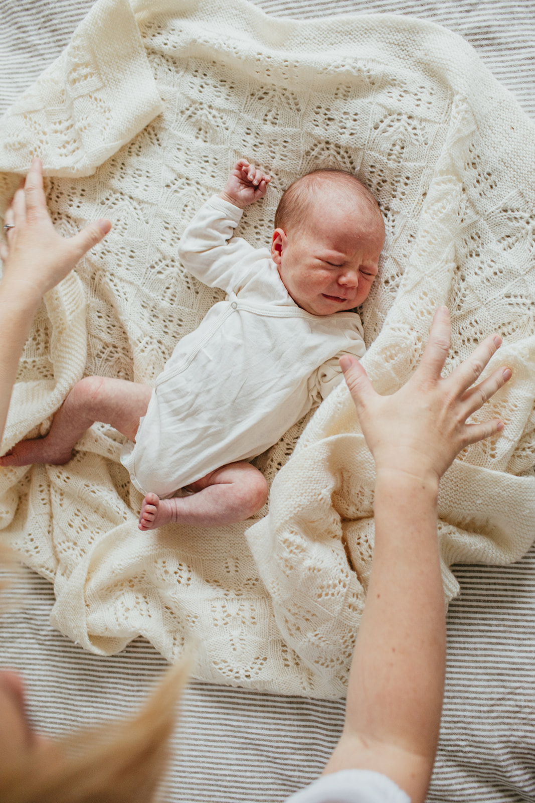 A newborn baby girl stretches during her photo shoot with Christchurch photographer Liv van Leeuwen.