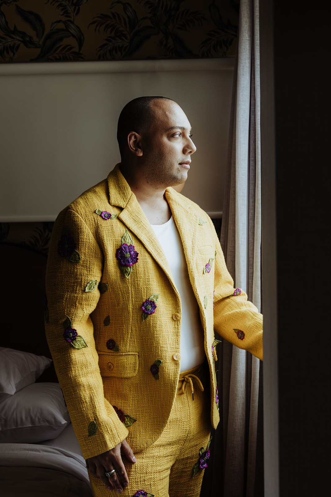 groom in yellow suit with purple embroidered flowers on it