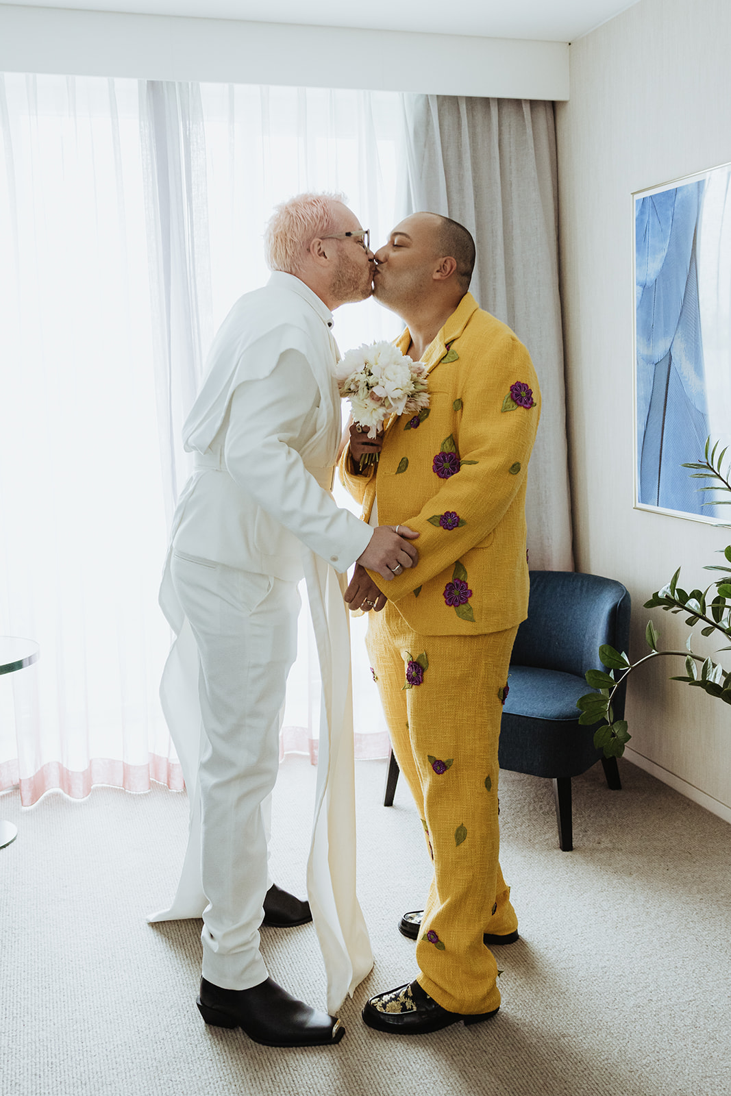 two grooms kissing after their first look