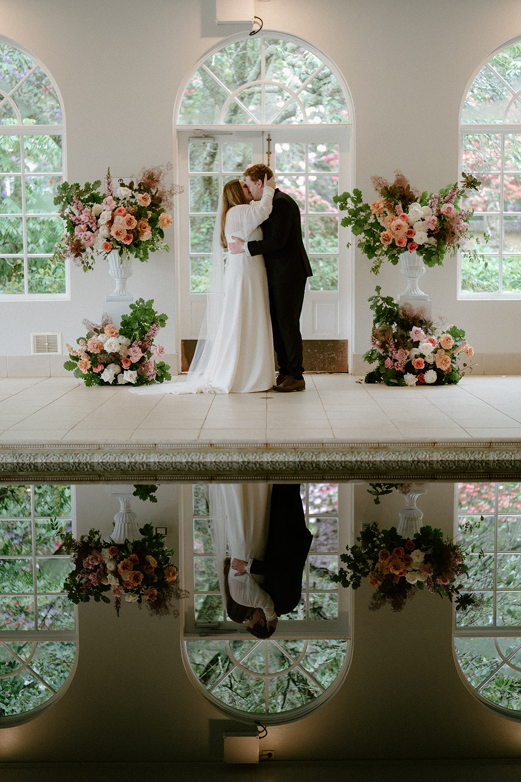 A bride and groom having their first kiss in the pool house at their Milton Park Country House wedding.