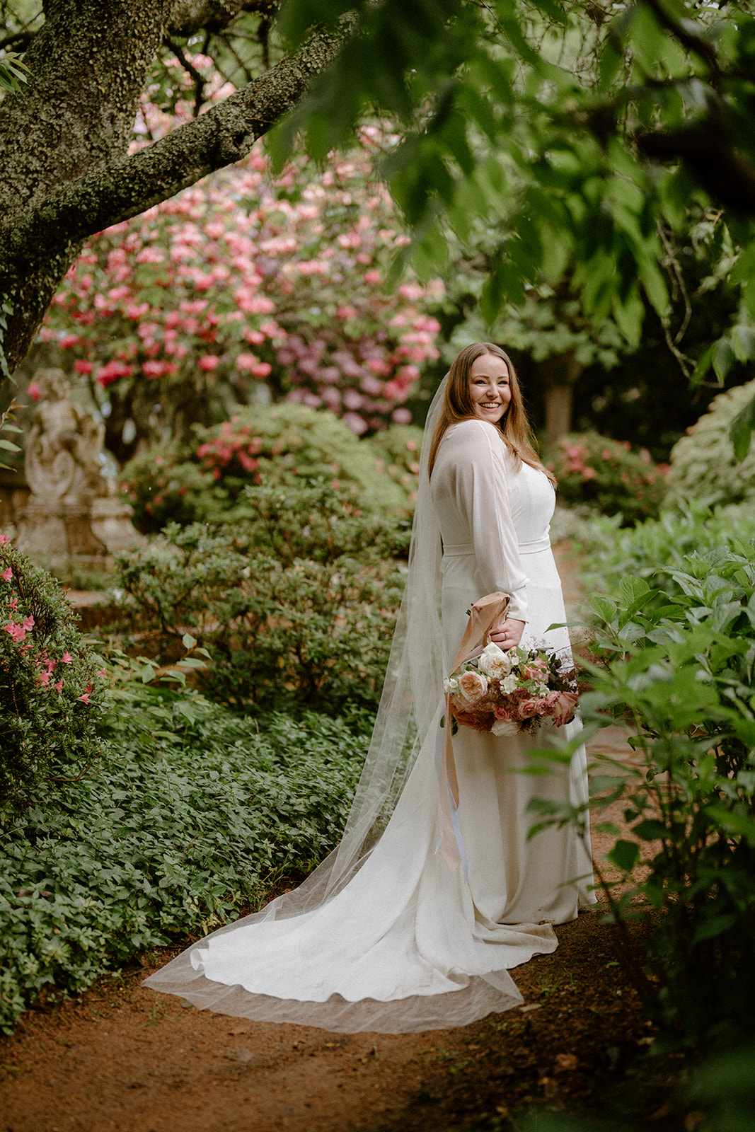A beautiful bride in her luxur wedding gown posing in front of greenery foliage at her Milton Park Country House wedding