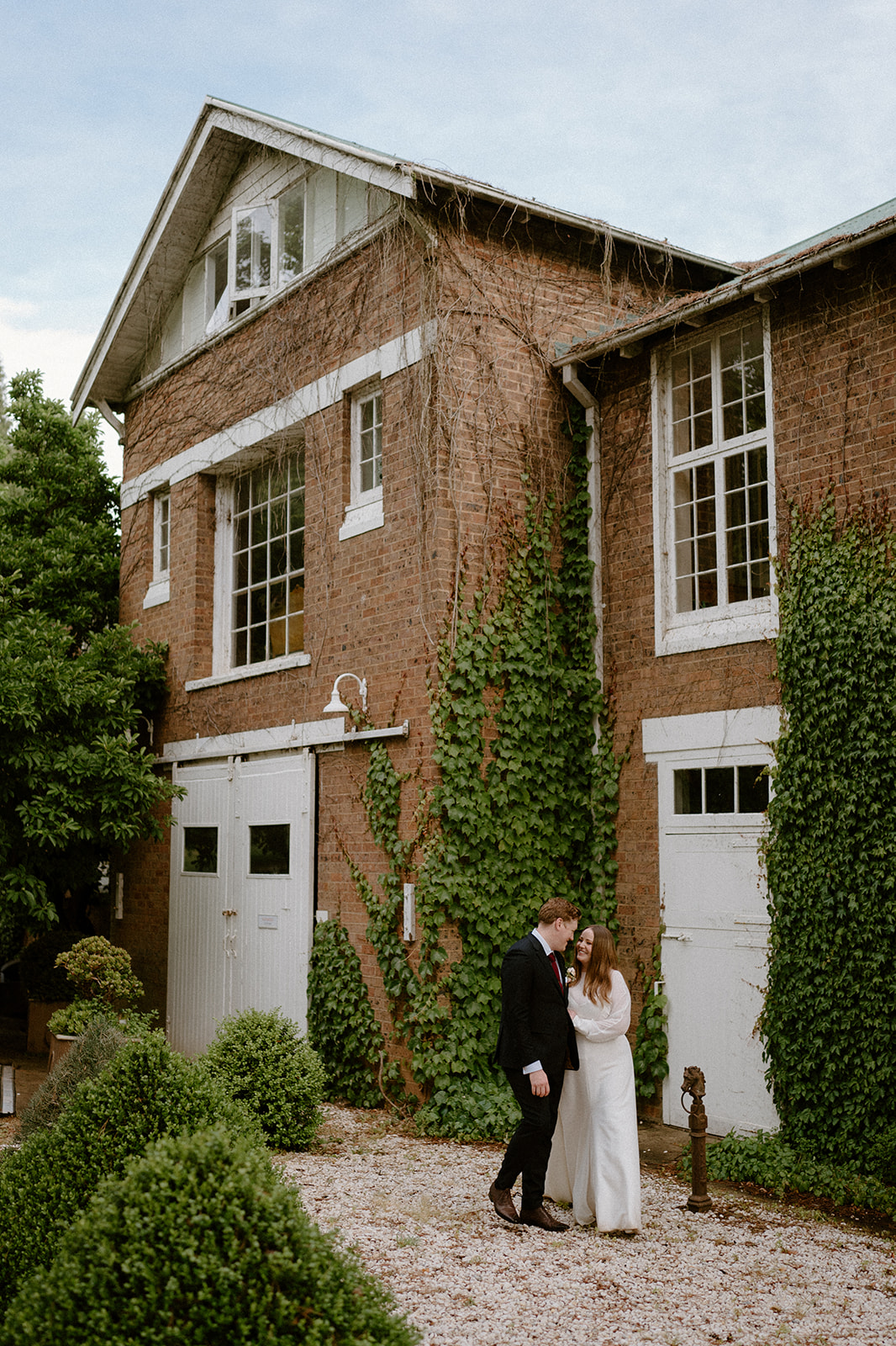 A newly wed couple walking in front of a heritage-listed building at their luxury Milton Park Country House wedding.