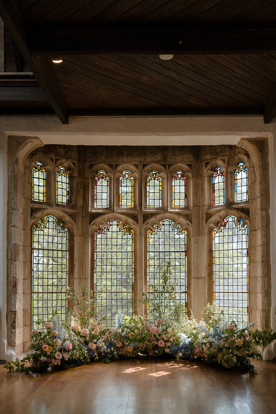 Lush floral arrangements adorn the altar at Montsalvat, creating a romantic ambiance for a wedding ceremony