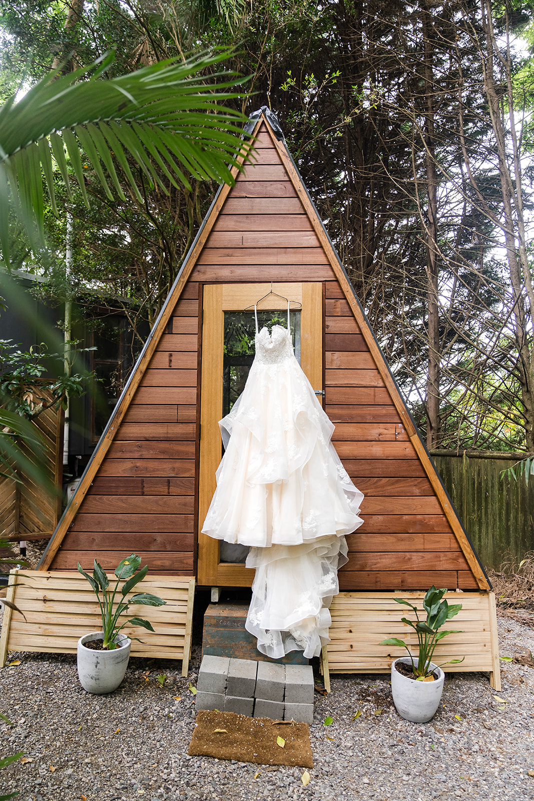 Bride dress hanging on outdoor cabin.