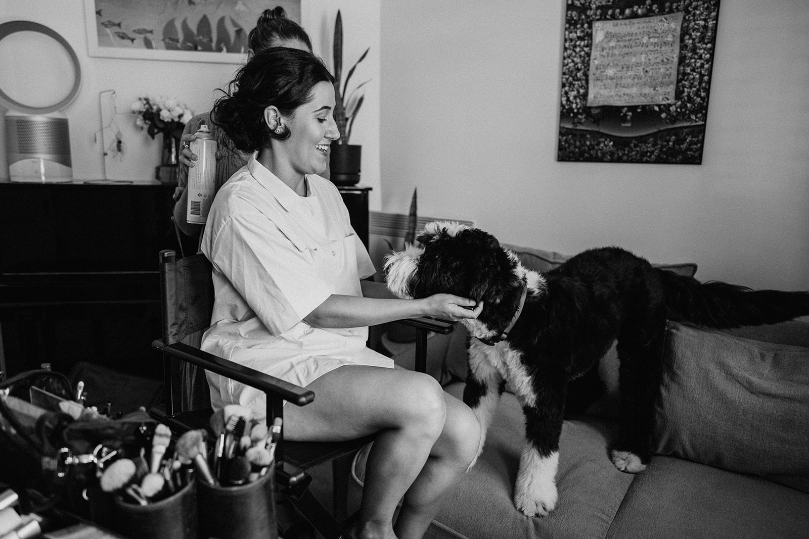 bride in makeup chair patting dog