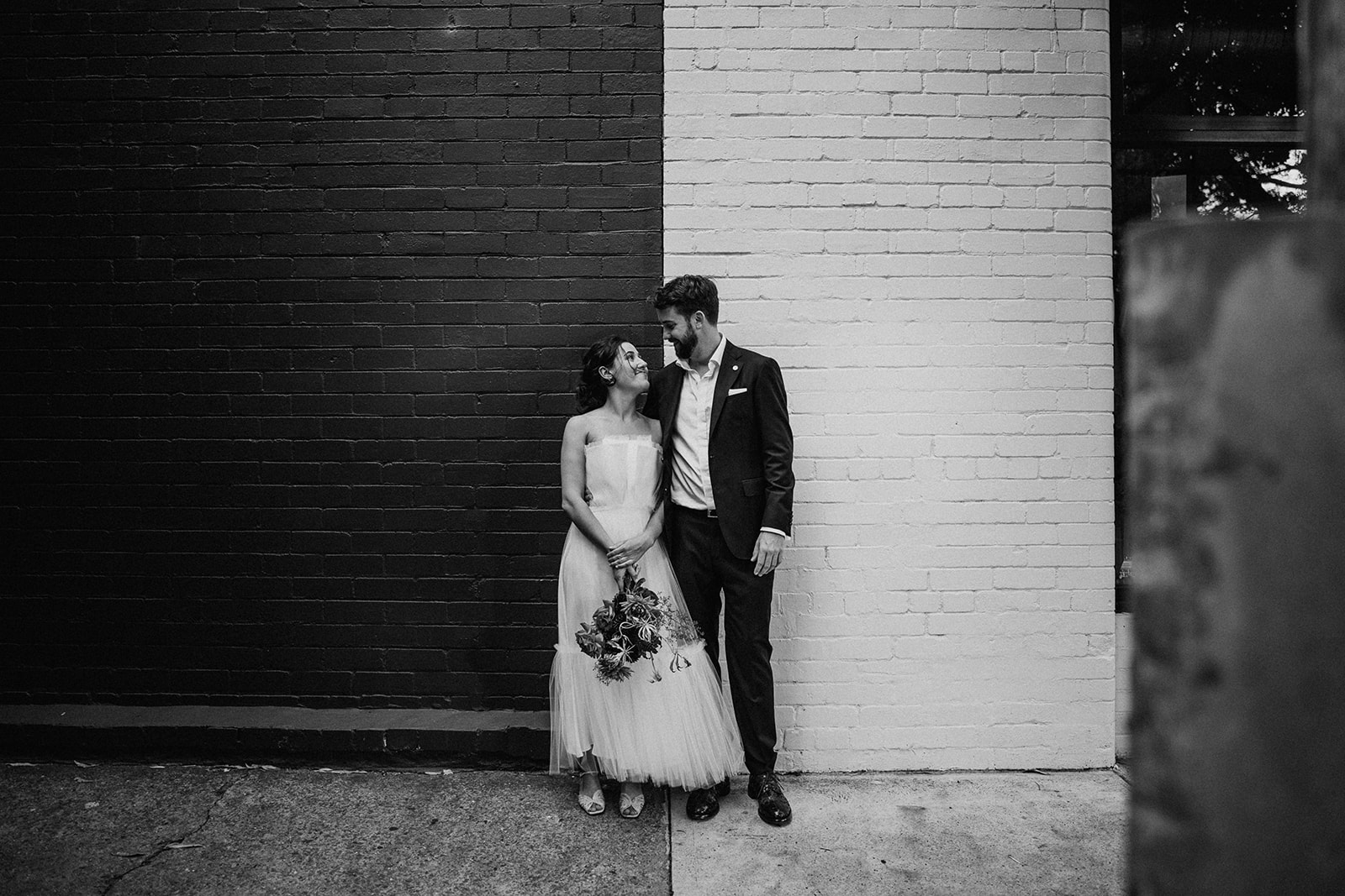 Scott Surplice portrait of bride and groom on black and white wall